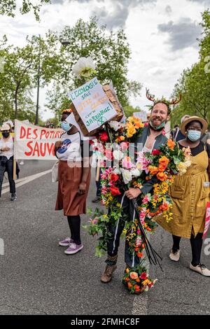 Paris, France. 9th May, 2021. A shame, an ecologist covered in plastic flowers who promotes the virtues of gardening during the march for the climate. Stock Photo