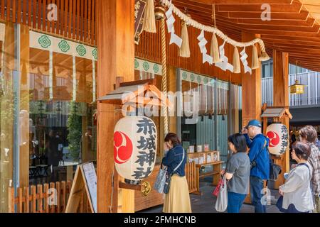 tokyo, japan - march 02 2020: Japanese queuing and praying in the Akagi shrine of Kagurazaka adorned with paper lanterns and sacred shimenawa rope ded Stock Photo