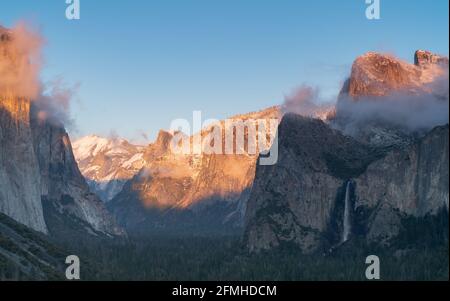winter sunset shot of snow on yosemite's half dome as storm clouds clear from yosemite national park Stock Photo