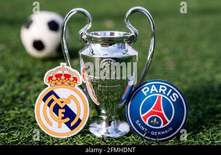 April 16, 2021 Moscow, Russia. The UEFA Champions League Cup and the emblems of the football clubs Paris Saint-Germain F. C. and Real Madrid CF on the
