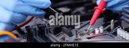Hands in rubber gloves repairing computer closeup Stock Photo