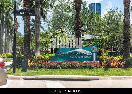 Sunny Isles Beach, USA - May 8, 2018: Residential area in Miami, Florida with sign for Gwen Margolis park in summer with flowers garden Stock Photo