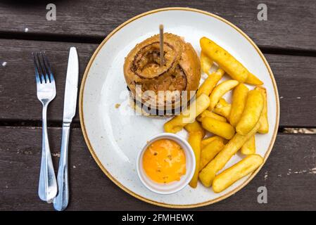 Burger and Chips served with Burger sauce in Pub outdoor seating Stock Photo