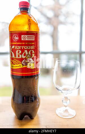 Herndon, USA - December 17, 2020: Table at home by window with bottle of storebought traditional Russian Kvass fermented bread drink with glass as ill Stock Photo