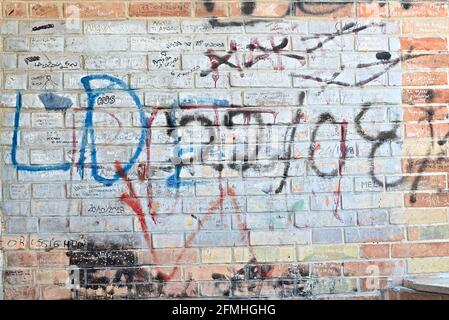 a colorful brick wall with spray can writing Stock Photo