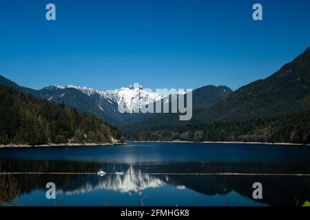 Capilano Lake with The Lions in the background in North Vancouver, British Columbia, Canada Stock Photo