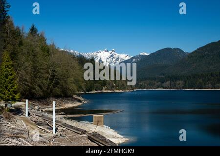 Capilano Lake with The Lions in the background in North Vancouver, British Columbia, Canada Stock Photo