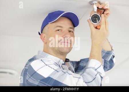 contractor installing surveillance cctv cameras in office Stock Photo