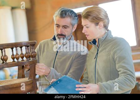 carpenters in furniture factory inspecting piece Stock Photo