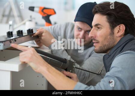 two men installing a new kitchen hob Stock Photo