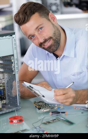 male technician writing on laptop Stock Photo