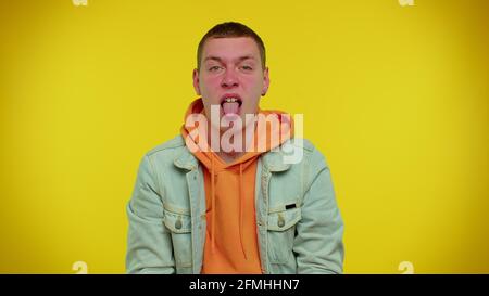 Funny teen man making playful silly facial expressions and grimacing, fooling around showing tongue Stock Photo