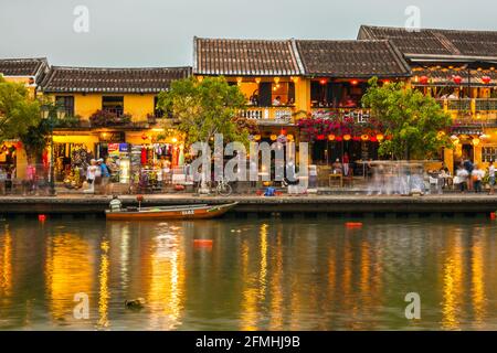 Colourful lights reflected on water by the riverside in Old Town (taken with a long exposure leaving light trails), Hoi An, Vietnam Stock Photo
