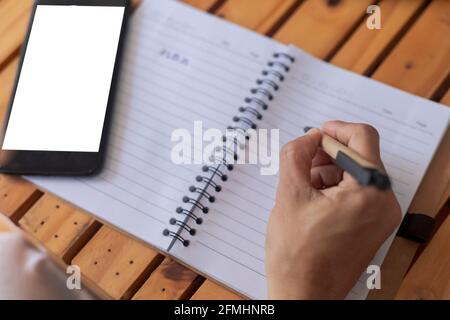 Top view Business women use pen writing document paper. Female hand close up writing with a blue pen on a white sheet. Woman writes information on a p Stock Photo