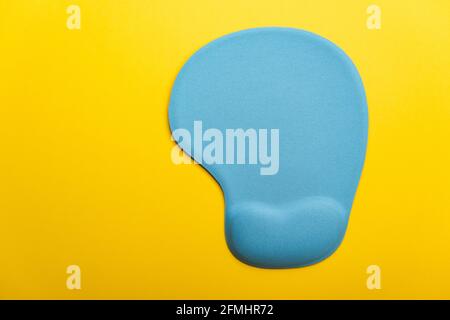 Top view flat lay of blue pad or mousepad for computer mouse modern design isolated on a yellow background and copy space Stock Photo