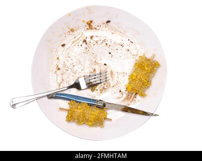 Eaten Meal with sweetcorn with Knife Folk and Plate on a white background Stock Photo