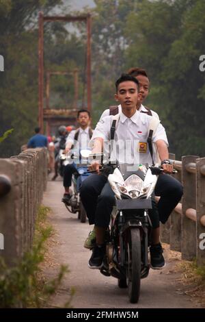 Yogyakarta, Indonesia. August 23, 2020. Junior high school students in Indonesia go to school using motorbikes over the bridge Stock Photo