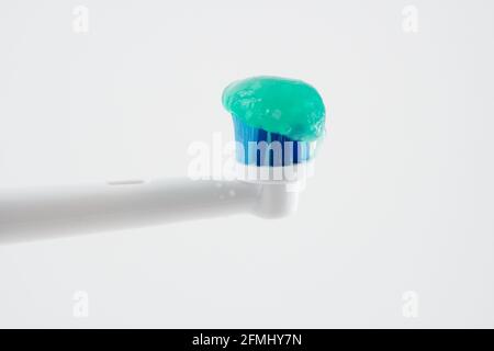 Generic automatic toothbrush head with green toothpaste on blue bristles Stock Photo