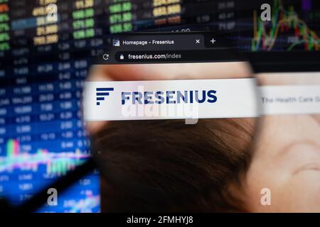 Fresenius company logo on a website with blurry stock market developments in the background, seen on a computer screen through a magnifying glass Stock Photo