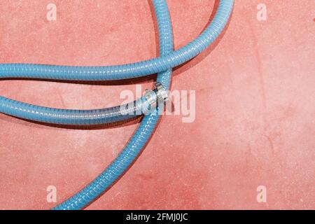 Top view of plastic ribbed hose with metallic connector and shiny surface in industrial workspace Stock Photo