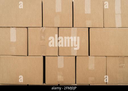 Textured background of rows of carton containers with adhesive tapes on beige surface in warehouse Stock Photo