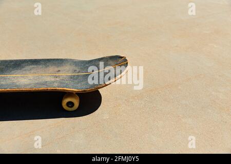Close-up of a worn skateboard on concrete paving Stock Photo