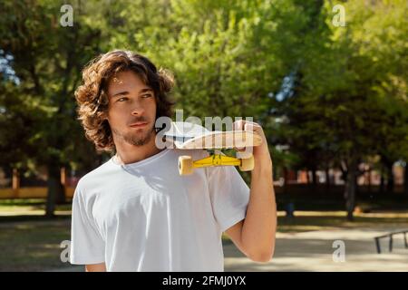 Portrait of a skateboarder holding his board over one shoulder. Stock Photo