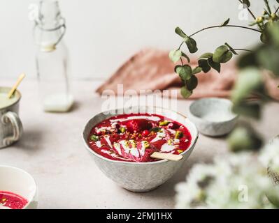 From above of tasty smoothie with fresh berries and ice candy with crushed pistachios and yogurt in bowl Stock Photo