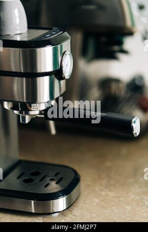 Contemporary stainless steel coffee maker with pressure gauge on table in house on blurred background Stock Photo