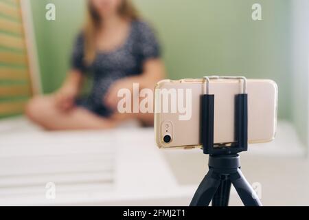 Young expectant female using screwdriver while assembling baby cot and sitting on floor at home Stock Photo