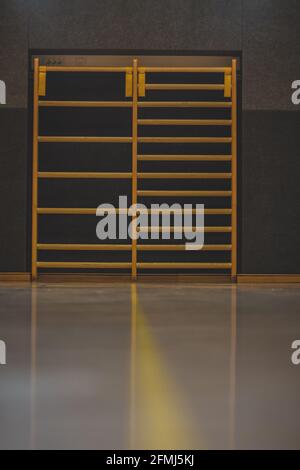 Frontal view of a wooden fitness ladder or bars, mounted on a wall in gym. Empty fitness bars. Stock Photo