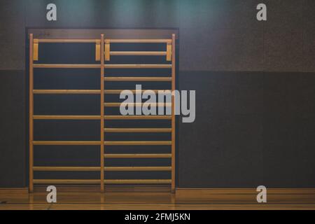 Frontal view of a wooden fitness ladder or bars, mounted on a wall in gym. Empty fitness bars. Stock Photo