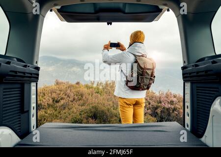 Serious black male model in trendy white suit and authentic African shirt with frown while standing in grassy field Stock Photo