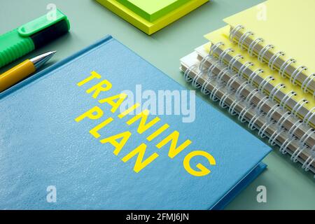 Training plan and stack of notebooks with pen. Stock Photo