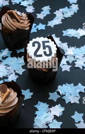 Number 25 on Delicious chocolate cupcake with cream on dark background. Muffin. Birthday cake party. 25 years old anniversary Stock Photo