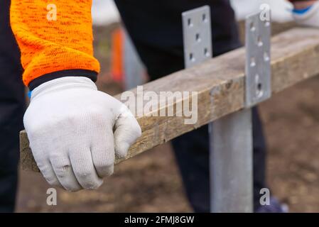 the builder twists the foundation made of screw piles. Lightweight and fast screw pile foundation is well suited for solar panels, terraces Stock Photo