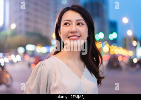 Young Asian woman walking on the street at night Stock Photo
