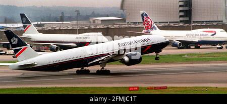 A British Airways Boeing 777 takes off at Heathrow Nov 1999 past BA Boing 747 jumbo jets waiting at London Airport Stock Photo