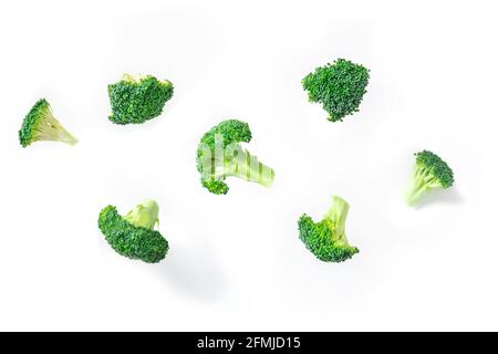 Broccoli florets flying on a white background. The concept of a healthy vegan diet with floating pieces of vibrant green broccoli Stock Photo