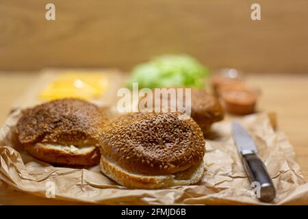 https://l450v.alamy.com/450v/2fmjd6b/burger-bread-lettuce-and-cheese-on-the-table-process-of-cooking-self-made-burgers-at-home-2fmjd6b.jpg