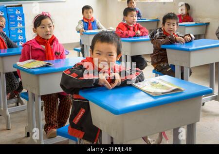 This rural school was destroyed during the 2008 Sichuan earthquake. Student shows his gratitude for our school rebuilding the school and  new desks. Stock Photo
