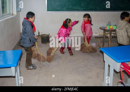 Students sweep their classroom in a rural school in Sichuan that was destroyed by the 2008 earthquake. My school helped rebuild by raising funds. Stock Photo