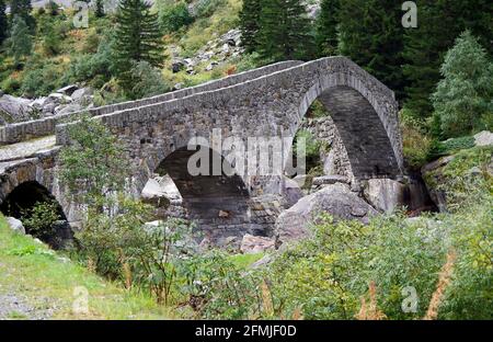 The Haderlisbrucke, arched stone bridge of 1649 over the river Reuss, in the Schollenen gorge near Goschenen, Switzerland Stock Photo