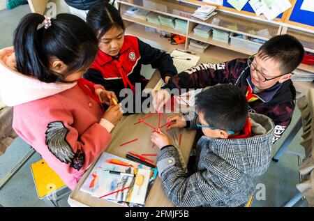 Primary students at BoAi work on their Design&Technology work in building a tower. Stock Photo