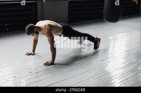 Young muscular athlete doing suspension pushups Stock Photo