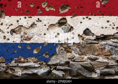 Concept of the Political Situation in the Netherlands with a damaged painted flag on a cracked wall with wholes. 3D-Illustration. 3D-rendering Stock Photo