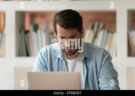 Close up confident businessman in glasses working on laptop Stock Photo