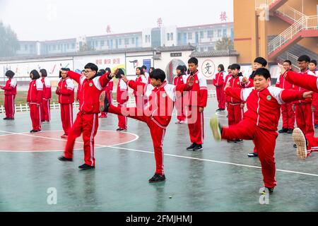 Students at a primary school in Lixian, Hebei, China doing their PE by doing wushu exercise. Stock Photo