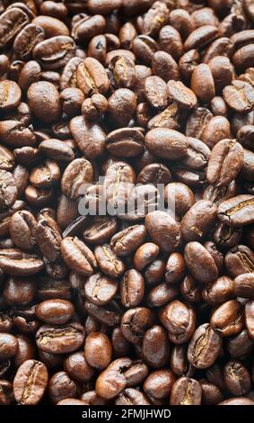Dark freshly roasted coffee beans background, selective focus. Stock Photo