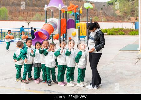 The teacher at BoAi school leads the student back to the classroom Stock Photo